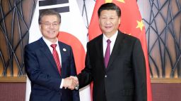 In this Nov. 11, 2017, photo released by China's Xinhua News Agency, South Korean President Moon Jae-in, left, and Chinese President Xi Jinping shake hands as they pose for a photo during a meeting on the sidelines of the Asia-Pacific Economic Cooperation (APEC) Forum in Danang, Vietnam. (Ding Lin/Xinhua via AP)