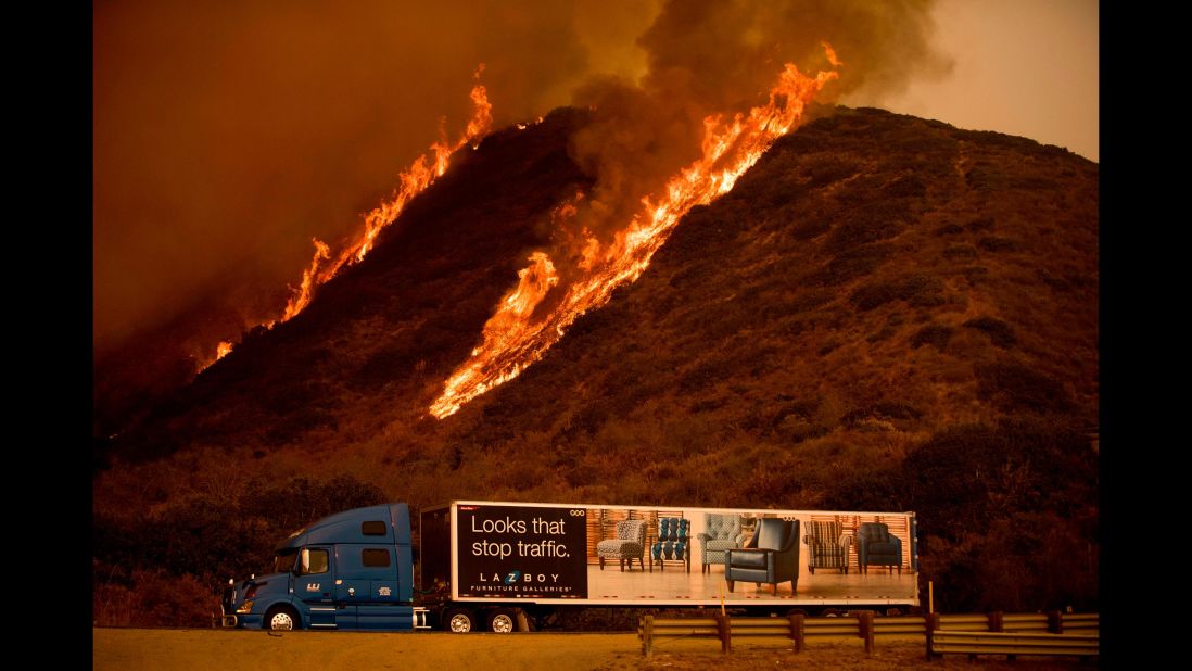 Flames from the Thomas Fire burn above a truck north of Ventura on December 6.