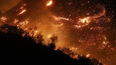 The Creek Fire burns on a hillside in the Shadow Hills neighborhood in Los Angeles. Strong Santa Ana winds are rapidly pushing multiple wildfires across the region.
