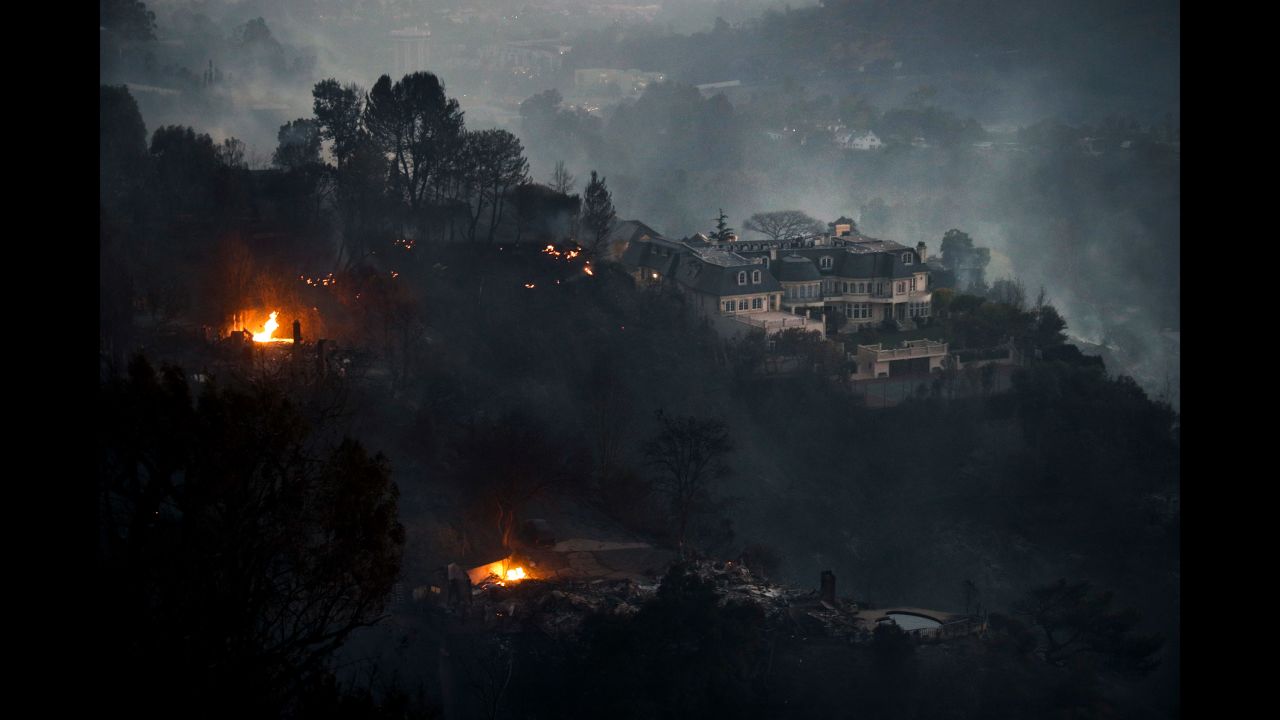 Fires surround a hilltop mansion in Los Angeles on Wednesday, December 6.
