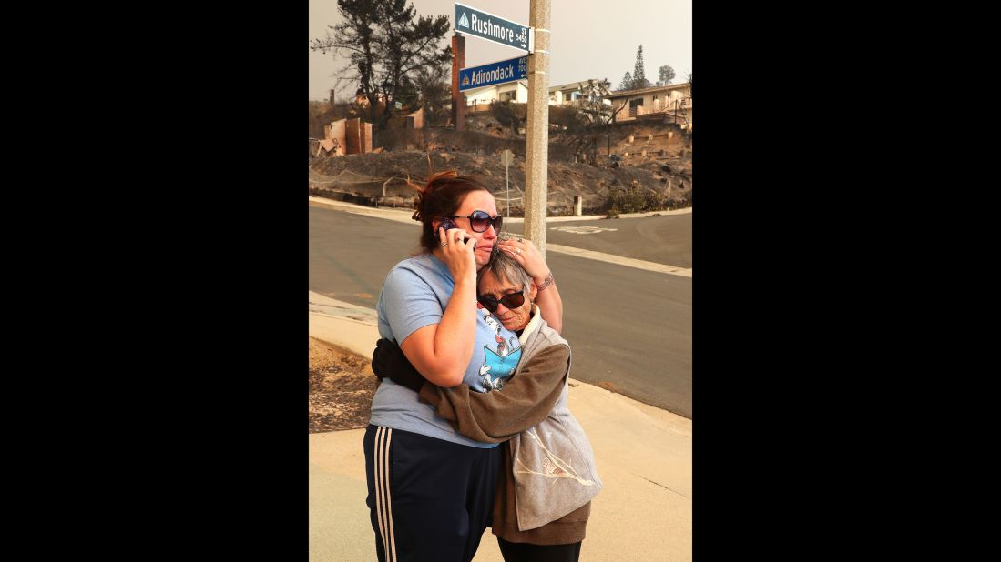 Joyce George, right, comforts neighbor Dawn Reily on December 6. Reily's Ventura home was destroyed by fire.