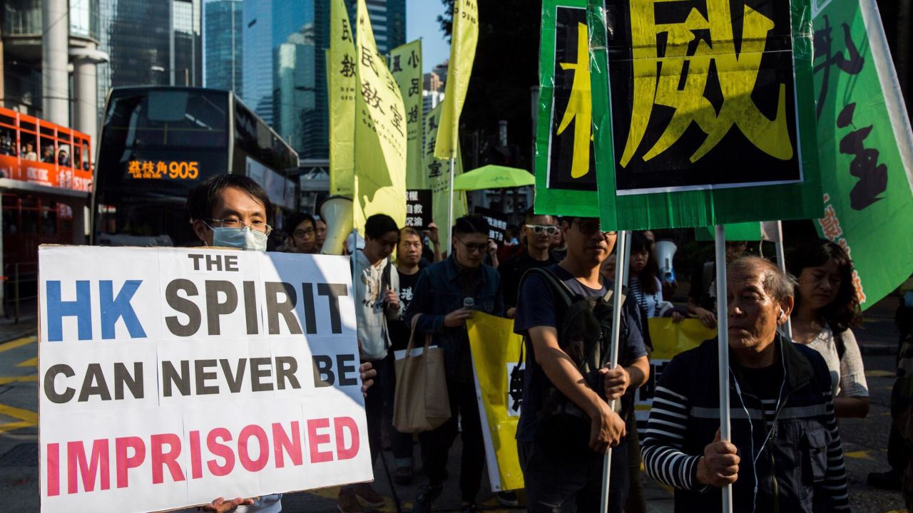 A protester holds up a placard during an "anti-authoritarian" march in Hong Kong on December 3, 2017. 