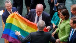 North Sydney federal Liberal MP Trent Zimmerman celebrates with the rainbow flag after parliament passed the same-sex marriage bill in the Federal Parliament in Canberra on December 7, 2017. 
Gay couples will be able to legally marry in Australia after a same-sex marriage bill sailed through parliament on December 7, ending decades of political wrangling. / AFP PHOTO / SEAN DAVEY