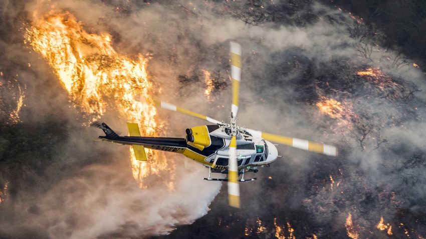 epaselect epa06372496 A Los Angeles County Fire helicopter flies over during the 'Skirball Fire' which began early morning in Bel-Air, California, USA, 06 December 2017. An outbreak of several fires North of Los Angeles has occurred as one of the strongest Santa Ana winds forecast of the season is ongoing and expected to last several days.  EPA-EFE/JOHN CETRINO