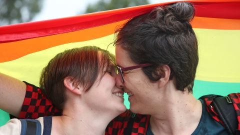 Alice Bennett and her partner Miranda Hill nuzzle each other among a crowd who gathered to watch the announcement on a large television screen at Federation Square in Melbourne, Australia on December 7.
