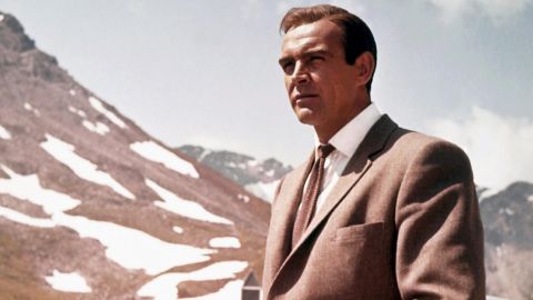 Connery poses as James Bond next to his Aston Martin DB5 in a scene from "Goldfinger" in 1964. Bond is often seen in the movies driving the car at high speed.