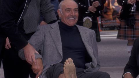 Connery shows his feet to the crowd on the Hollywood Walk of Fame during his Hand and Footprint Ceremony at the Mann Chinese Theater in Hollywood in 1999.