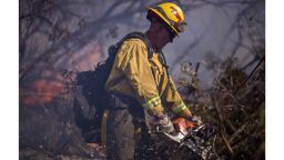 FILLMORE, CA - DECEMBER 07:  A firefighter cuts brush at the Thomas Fire on December 7, 2017 near Fillmore, California. Strong Santa Ana winds are pushing multiple wildfires across the region, expanding across tens of thousands of acres and destroying hundreds of homes and structures.  (Photo by David McNew/Getty Images)