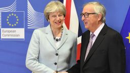 British Prime Minister Theresa May (L) is welcomed by European Commission Jean-Claude Juncker at European Commission in Brussels on December 8, 2017. / AFP PHOTO / EMMANUEL DUNAND