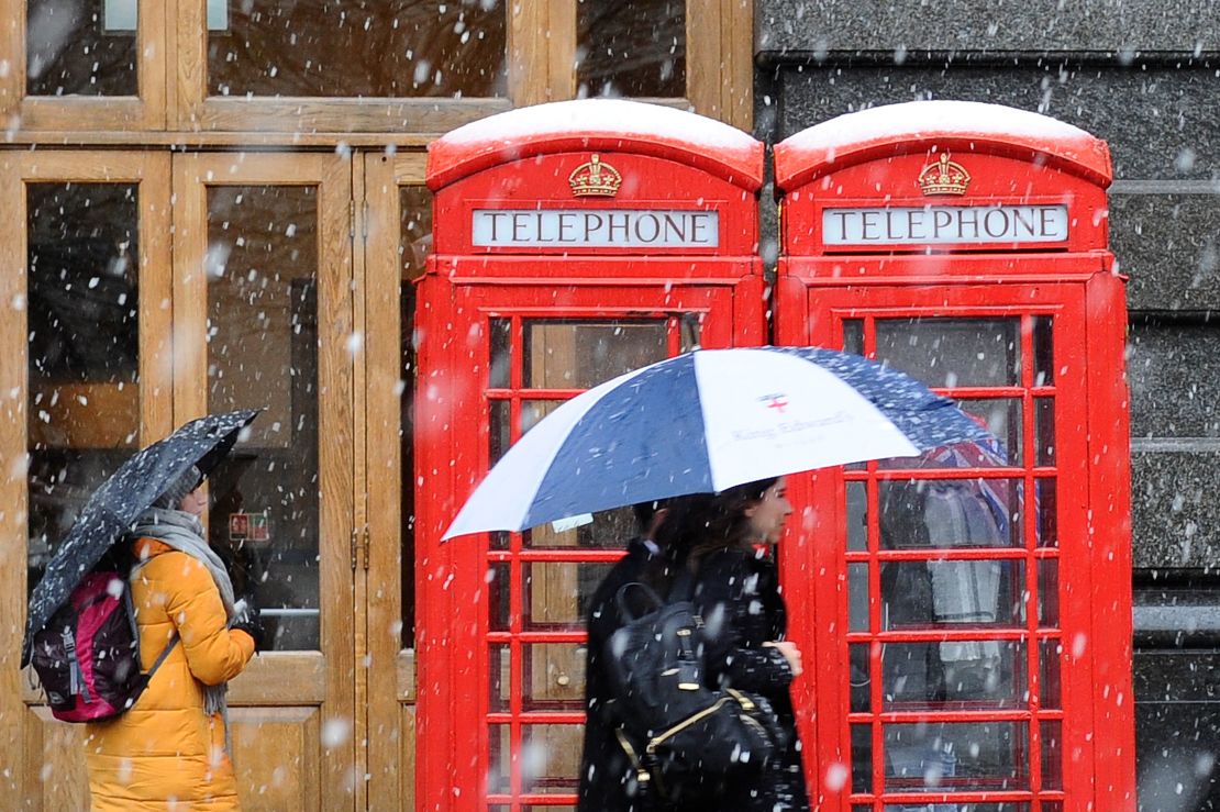 Snow falls on crowds in central London on Sunday.
