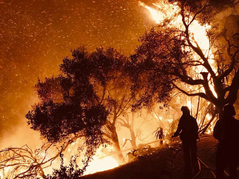 Firefighters battle a wildfire as it advances on homes in Carpinteria on December 10.