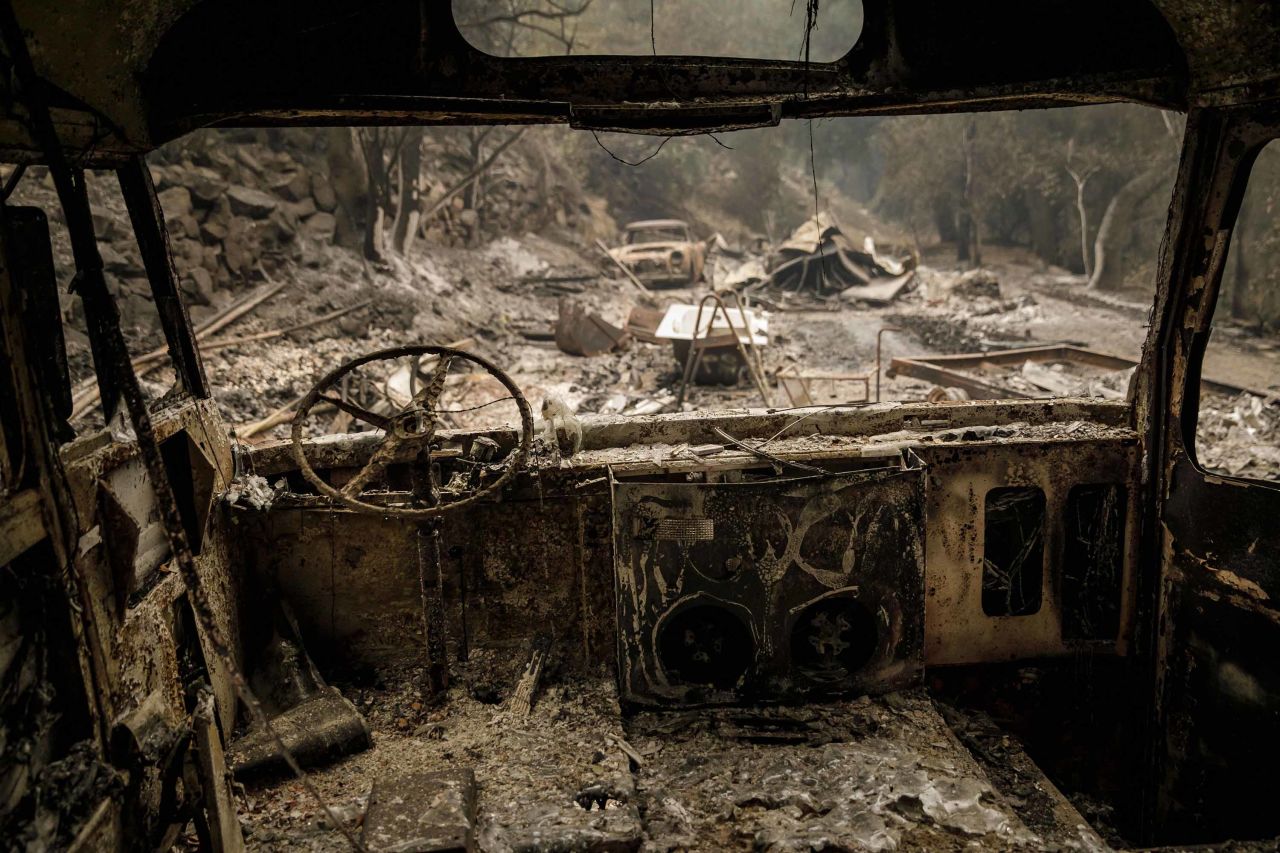 The shell of a burnt-out bus is seen after fire swept through residential neighborhoods near Ojai on Friday, December 8.