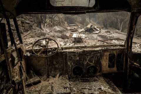 The shell of a burnt-out bus is seen after fire swept through residential neighborhoods near Ojai on Friday, December 8.