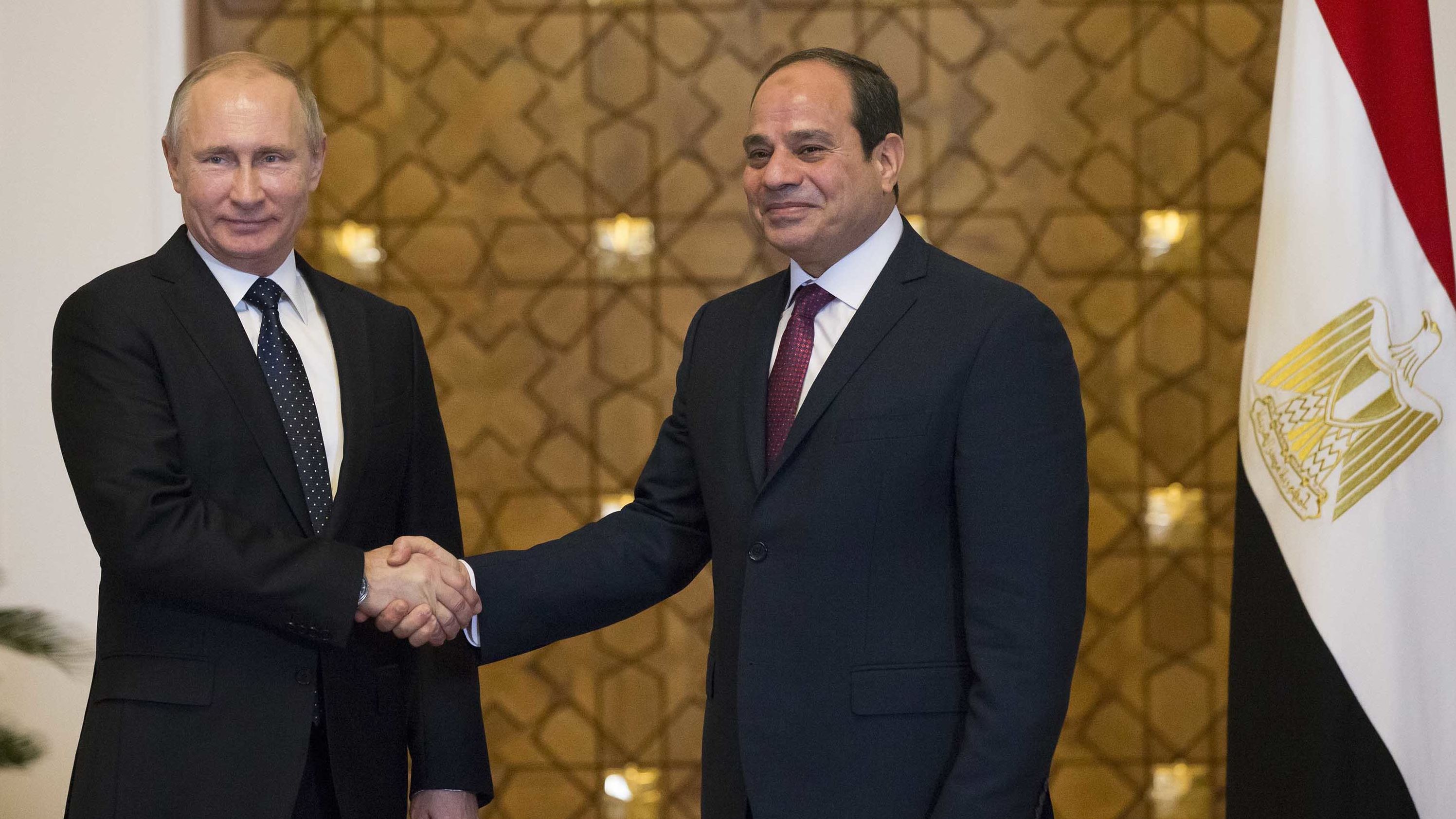Putin (L) and Sisi shake hands during their meeting in Cairo on Monday.