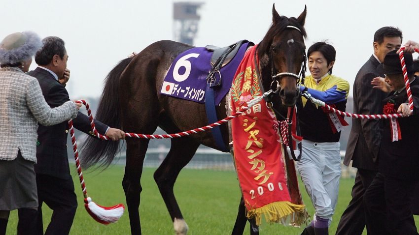 TOKYO, JAPAN - NOVEMBER 26: Jockey Yutaka Take who rode Deep Impact of Japan to victory in the 26th Japan Cup holds the horse at Tokyo Race Course on November 26, 2006 in Tokyo, Japan.  Britain's Ouija Board, ridden by Frankie Dettori came third . (Photo by Junko Kimura/Getty Images)
