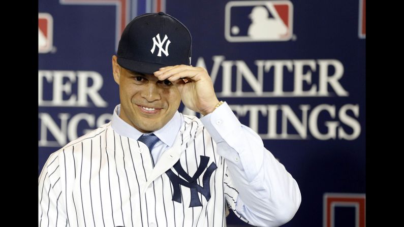 Giancarlo Stanton adjusts his cap as he is presented as the newest member of the New York Yankees on Monday, December 11. Stanton, the National League MVP who hit 59 home runs this past season, <a href="index.php?page=&url=http%3A%2F%2Fbleacherreport.com%2Farticles%2F2748746-report-marlins-threatened-giancarlo-stanton-to-accept-giants-cardinals-trade" target="_blank" target="_blank">was traded to the Yankees from Miami. </a>The Marlins received second baseman Starlin Castro and two minor-league prospects, Jorge Guzman and Jose Devers.