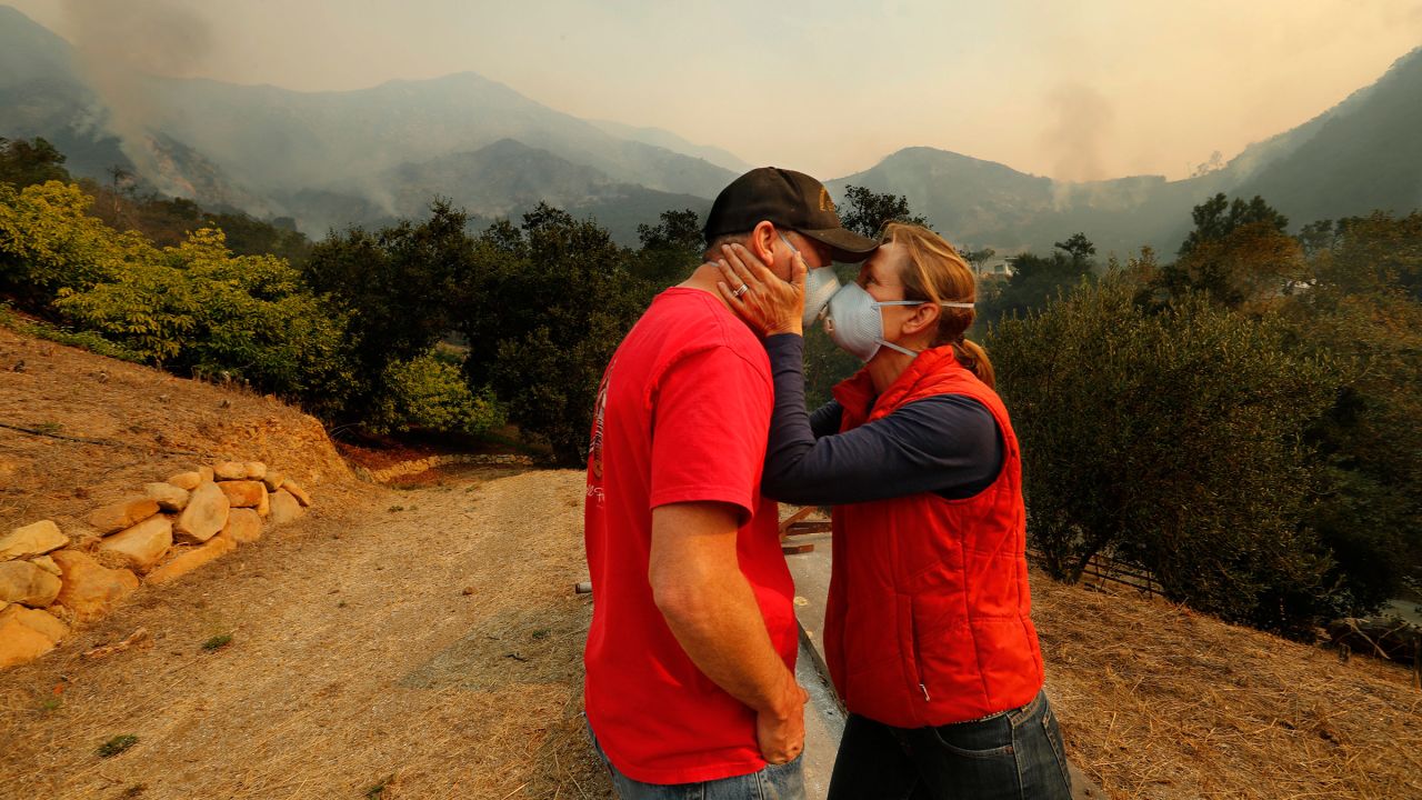 As the Thomas Fire burns in the background, Dan Bellaart and his wife, Mary McEwen, comfort each other in their backyard in Montecito, California, on December 11.