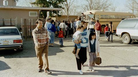 A couple leaves the Cleveland Elementary School in Stockton, California,  with their children after a gunman shot and killed five students and then turned the gun on himself. 