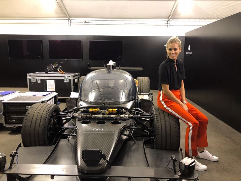 Nicki Shields poses with her rival, the AI race car DevBot at the Hong Kong ePrix earlier in December. 