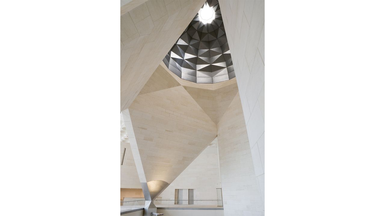 The museum's 164 foot atrium, hidden from view outside by the walls of a central tower, is crowned with an oculus that captures light from the desert sun and reflects it in patterns on the facets of the dome's walls. <br />