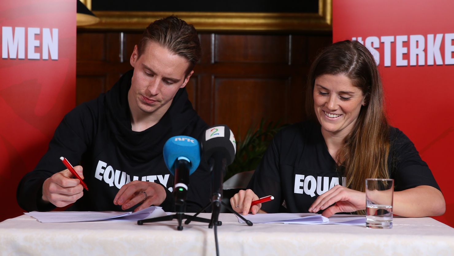 Stefan Johansen (L) and Maren Mjelde (R) sign the agreement in London.