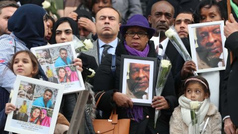 Mourners hold portraits of victims as they leave St. Paul's Cathedral following the national service.