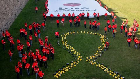 Firefighters place their helmets to form the shape of a giant yellow ribbon in Barcelona on November 20 to call for the release of jailed separatist activists.