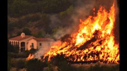 In this Thursday, Dec. 14, 2017, photo provided by the Santa Barbara County Fire Department, flames from a back firing operation underway rise behind a home off Ladera Lane near Bella Vista Drive in Santa Barbara, Calif. Red Flag warnings for the critical combination of low humidity and strong winds expired for a swath of Southern California at midmorning but a new warning was scheduled to go into effect Saturday in the fire area due to the predicted return of winds. The so-called Thomas Fire, the fourth-largest in California history, was 35 percent contained after sweeping across more than 394 square miles (1,020 sq. kilometers) of Ventura and Santa Barbara counties since it erupted Dec. 4 a few miles from Thomas Aquinas College. (Mike Eliason/Santa Barbara County Fire Department via AP)