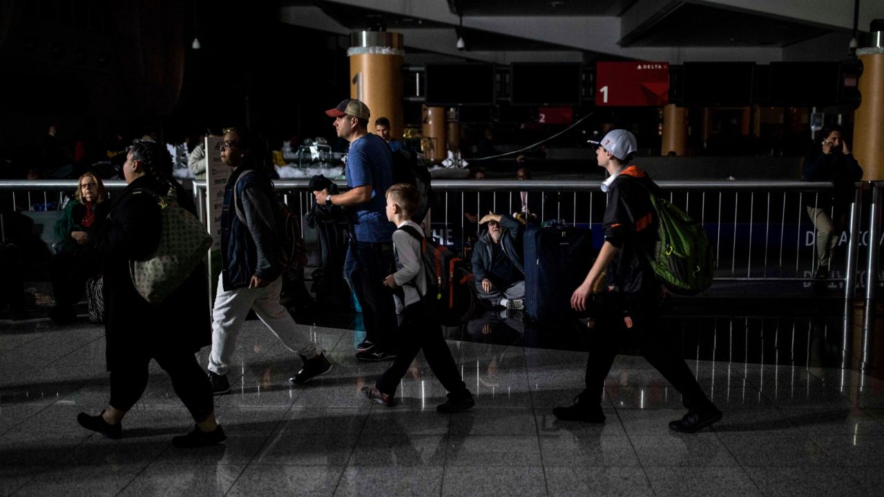 Passengers make their way through Hartfield-Jackson Atlanta International Airport after the lights went out at the airport.