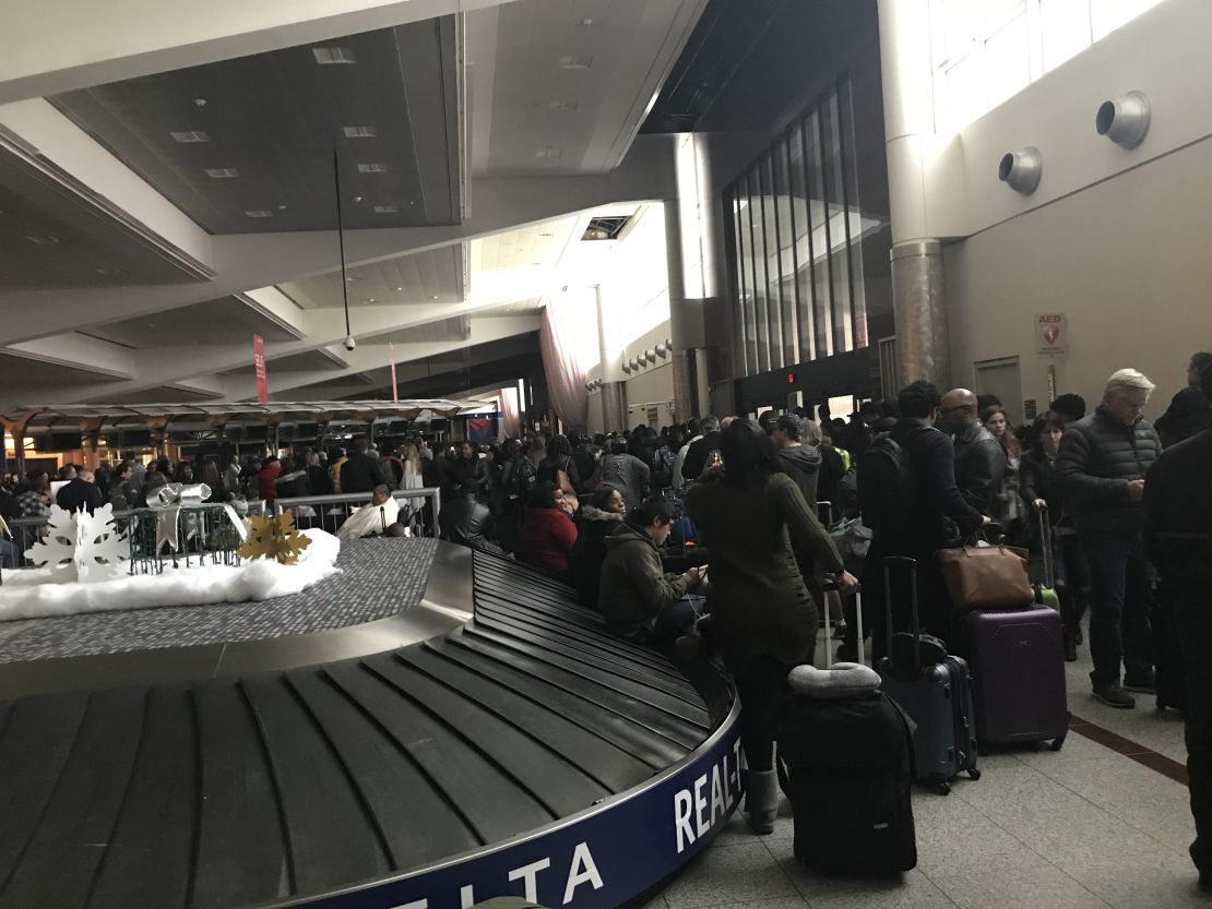Stranded passengers congregate around baggage claim Sunday. 