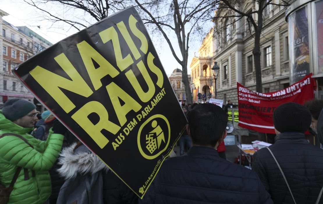 A demonstrator holds a poster 'Nazis out of the parliament' during a demonstration prior to the ceremony. 