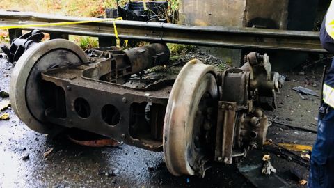 Part of the train chassis sits stripped on the highway.