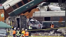 Cars from an Amtrak train that derailed above lay spilled onto Interstate 5 alongside smashed vehicles Monday, Dec. 18, 2017, in DuPont, Wash. The Amtrak train making the first-ever run along a faster new route hurtled off the overpass Monday near Tacoma and spilled some of its cars onto the highway below, killing some people, authorities said. (AP Photo/Elaine Thompson)