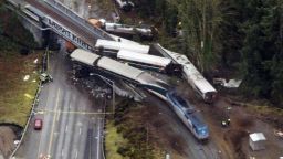 Cars from an Amtrak train that derailed above lie spilled onto Interstate 5, Monday, Dec. 18, 2017, in DuPont, Wash. The Amtrak train making the first-ever run along a faster new route hurtled off the overpass Monday near Tacoma and spilled some of its cars onto the highway below, killing several people, authorities said. (AP Photo/John Froschauer)