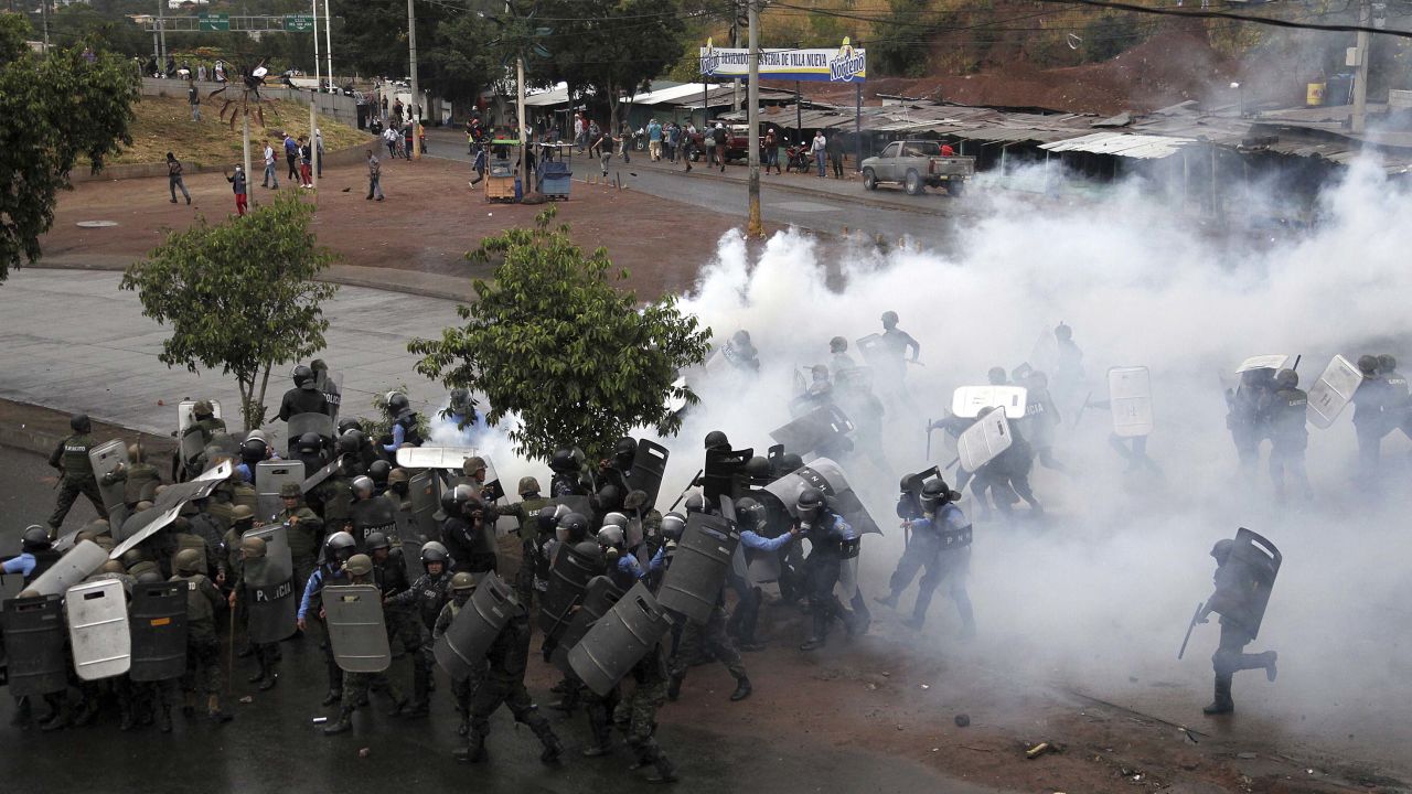Police stand amid tear gas as they clash with supporters of opposition presidential candidate Salvador Nasralla in Tegucigalpa, Honduras, Monday, Dec. 18, 2017. President Juan Orlando Hernandez has been declared the winner of Honduras' disputed election, but that isn't quelling unrest from weeks of uncertainty as his main challenger calls for more protests Monday and vows to take his claims of fraud to the OAS. (AP Photo/Fernando Antonio)