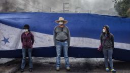 Protesters hold a Honduran flag as they block a road during protests against the presidential election of Juan Orlando Hernandez in Tegucigalpa, Honduras, on Monday, Dec. 18, 2017. 