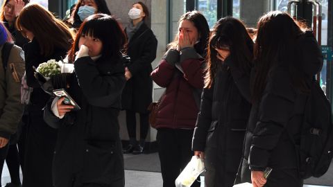 Tearful fans gather at a mourning altar for Jonghyun at a hospital in Seoul on December 19, 2017.
