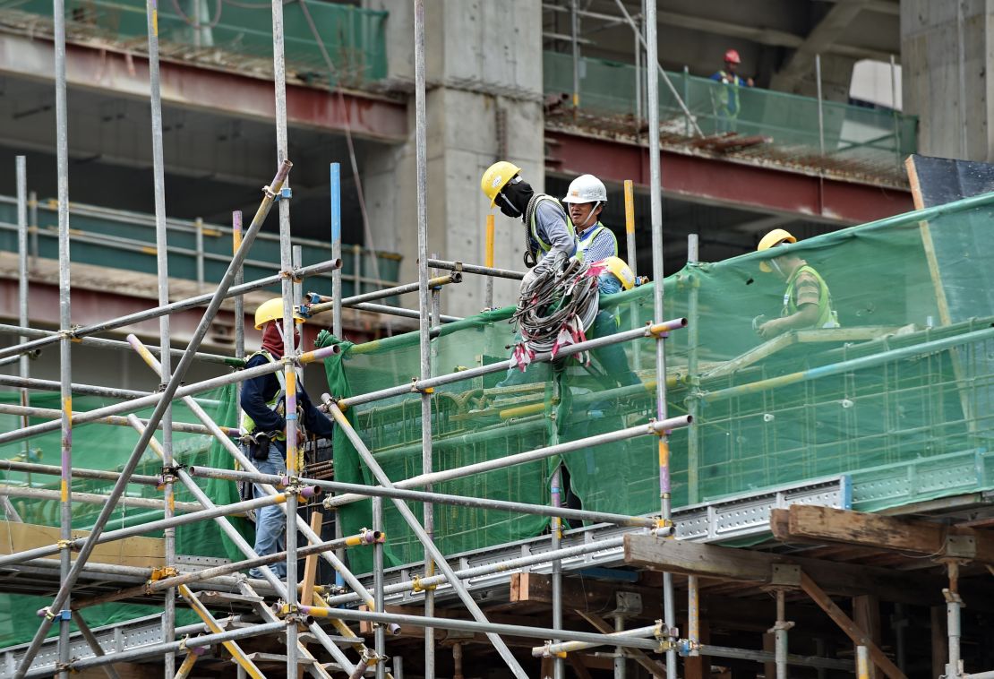 Labourers work at a construction site in the financial district in Singapore on August 8, 2014.
