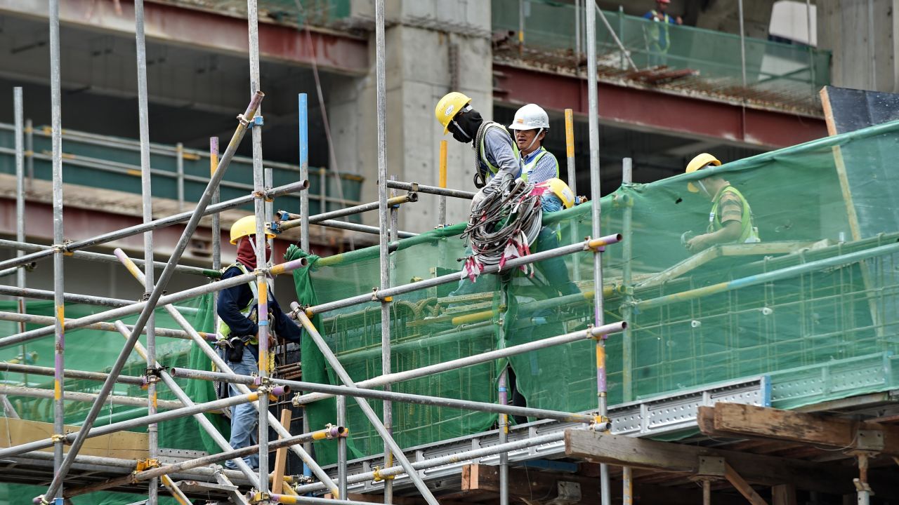 Labourers work at a construction site in the financial district in Singapore on August 8, 2014. 