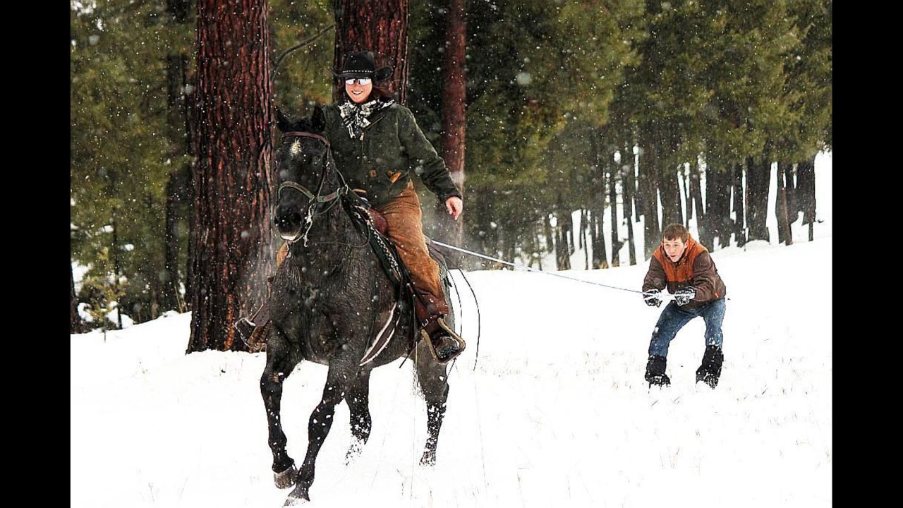 <strong>Horsing around: </strong>A mounted horse pulls the cross-country skier through forest trails and snow-filled meadows in skijoring, Triple Creek Ranch's newest cold-weather activity. 