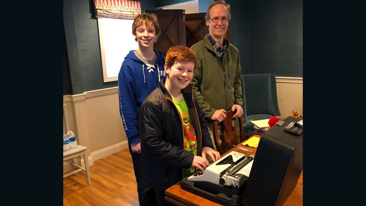 Members of the family stand with the typewriter given to them by Tom Hanks.