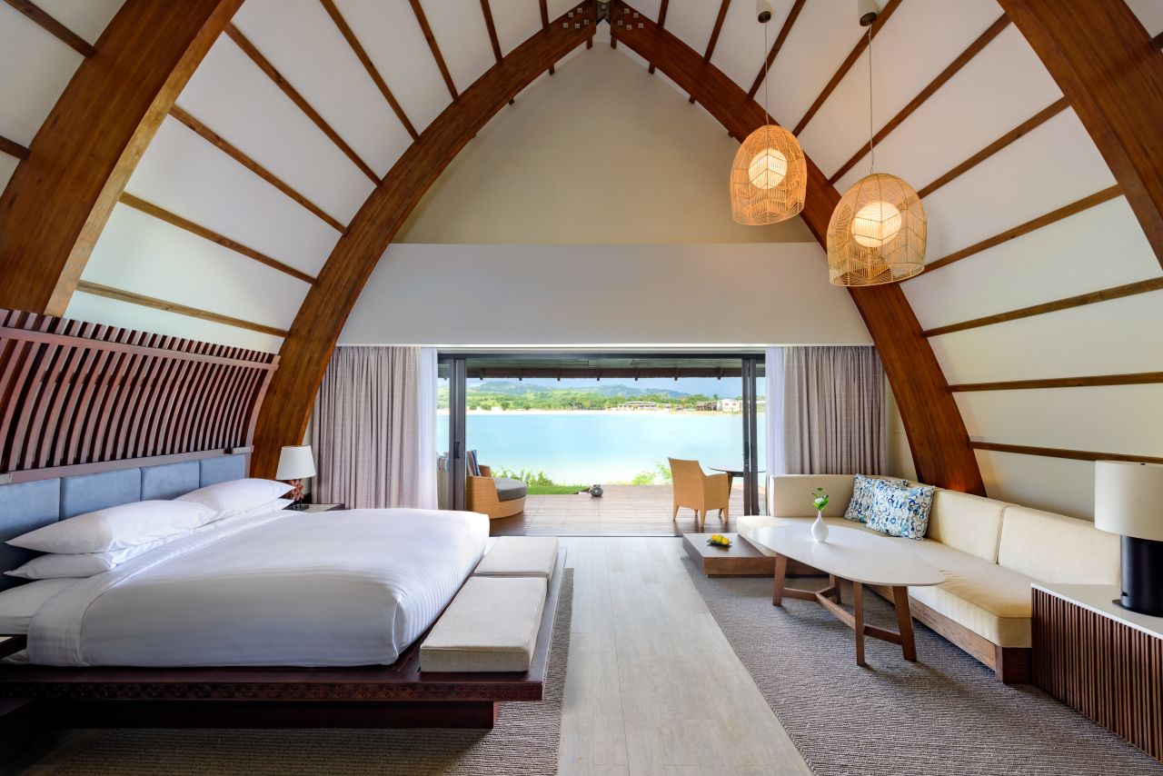 <strong>Fiji Marriott Resort Momi Bay:</strong> Designed by local firm Architect Pacific, the towering bures are intended to resemble the hull of a traditional <em>drua</em> boat (Fijian double canoes). The result is a balance between contemporary and rustic, featuring timber shingles, wood-clad interiors, and local resources, such as stone-top washbasins and Fijian mahogany bed frames. 
