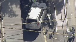 In this photo made video from the Australian Broadcasting Corp., a white SUV vehicle is stopped after allegedly striking pedestrians, Thursday, Dec. 21, 20217, in Melbourne, Australia. Local media say over a dozen people have been injured after a car drove into pedestrians on a sidewalk in central Melbourne. (Australian Broadcast Corp. via AP)
