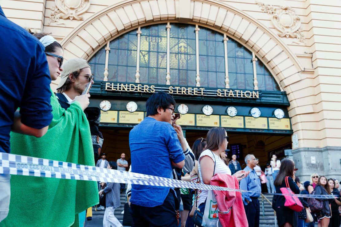 People gather at the scene of where a car ran over pedestrians in Flinders Street in Melbourne on December 21, 2017.
