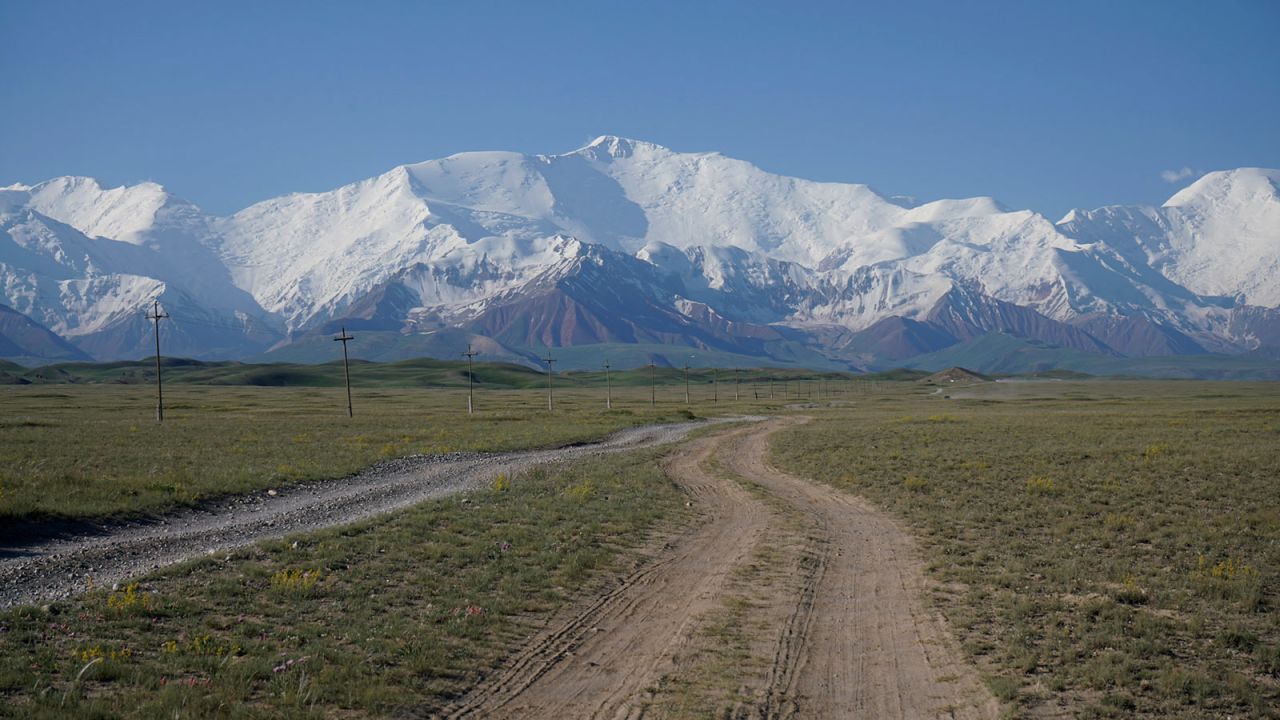 <strong>Lenin Peak: </strong>Lenin Peak (7,134 meters) looms large in the background on the road heading to the National Horse and Yak Games Festival outside of Sary-Mogol, in southern Kyrgyzstan. 