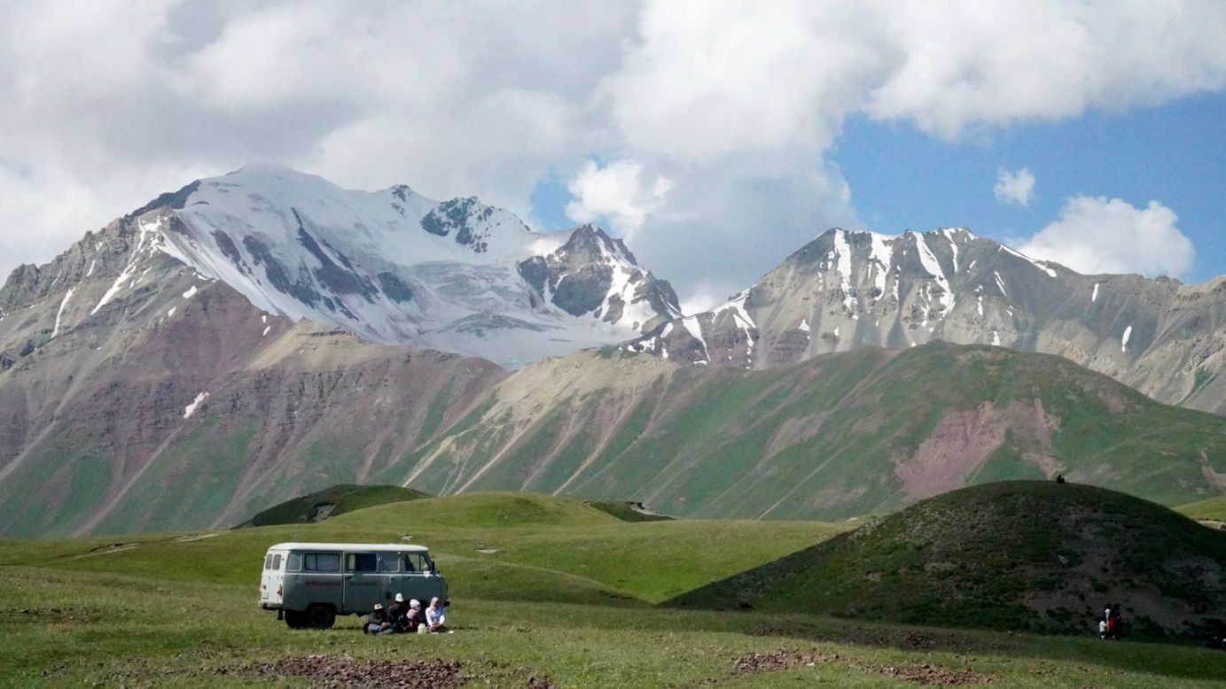 <strong>Vehicle of choice: </strong>A family relaxes under the shade of their UAZ Bukhanka -- a Soviet-produced 4x4 van. Ideal for navigating the rough terrain, it's the vehicle of choice in the region. 
