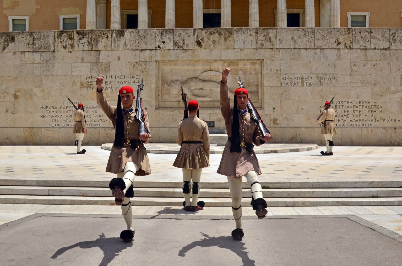 <strong>Changing of the guard:</strong> Athens old Royal Palace is guarded by the Evzoni guards, who dress in in their traditional red caps with long black tufts, pleated kilts and tsarouchi shoes. Visitors can wach the impressive Changing of the Guard.
