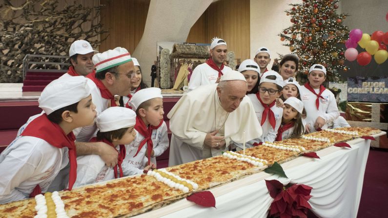 Pope Francis blows out a candle in celebration of his 81st birthday during an event with children at the Vatican on Sunday, December 17.