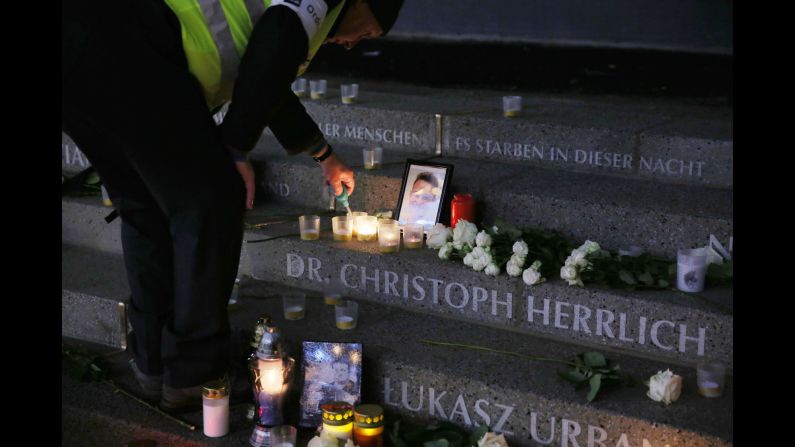 A person lights a candle at a memorial in Berlin, marking the first anniversary of a terrorist attack at a Christmas market on Tuesday, December 19. Twelve people were killed in <a href="http://www.cnn.com/2016/12/23/europe/berlin-christmas-market-attack-suspect-killed-milan/index.html" target="_blank">December 2016</a> and at least 48 were wounded when a man driving a tractor-trailer rammed into a crowd at a Christmas market filled with holiday shoppers in Berlin.