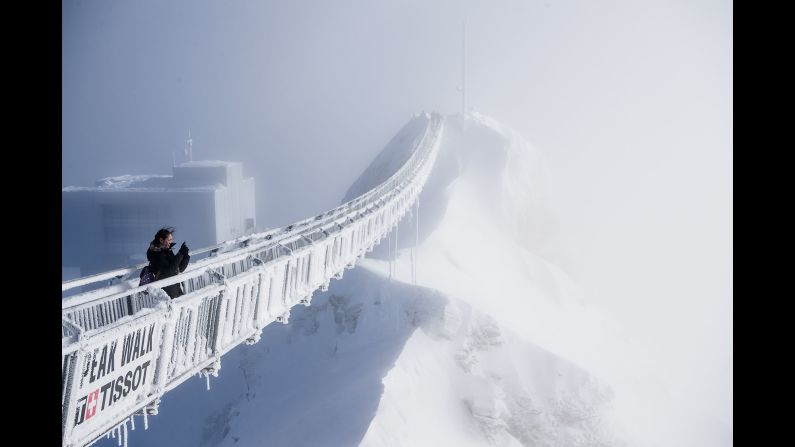 A tourist takes a photo from the "Peak Walk" suspension bridge in the Swiss Alps on Wednesday, December 20. The bridge, which is 107 meters long and 80 centimeters wide (about 351 feet long and 31 inches wide), is one of the world's first and connects two mountain peaks.